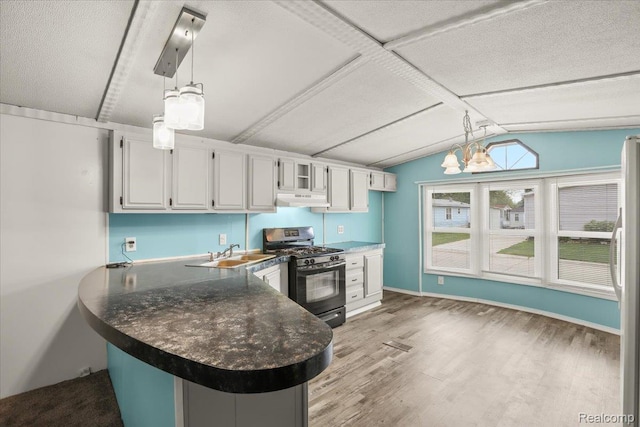 49831 Leicester Ct, Shelby Twp, MI 48315 - kitchen with black gas range oven, a sink, under cabinet range hood, dark countertops, and a peninsula