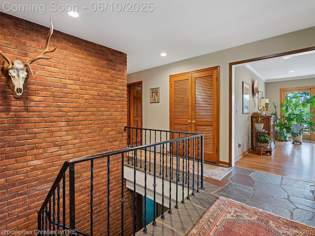 4383 Pine Tree Trl, Bloomfield Hills, MI 48302 - hallway with an upstairs landing, brick wall, recessed lighting, wood finished floors, and baseboards