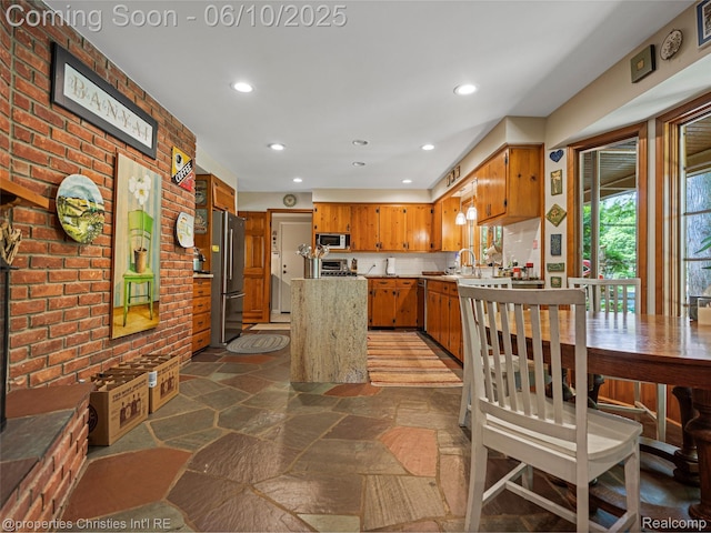 4383 Pine Tree Trl, Bloomfield Hills, MI 48302 - kitchen with stainless steel appliances, stone flooring, brick wall, light countertops, and recessed lighting