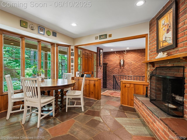 4383 Pine Tree Trl, Bloomfield Hills, MI 48302 - dining room featuring a fireplace, stone tile flooring, healthy amount of natural light, recessed lighting, and brick wall