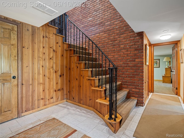 4383 Pine Tree Trl, Bloomfield Hills, MI 48302 - stairway with brick wall, baseboards, wood walls, and tile patterned floors