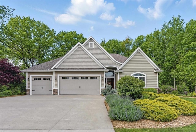 2887 E Iron Woods Pass, Midland, MI 48642 - view of front of home featuring a garage, concrete driveway, stone siding, and a shingled roof