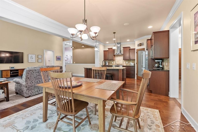 2887 E Iron Woods Pass, Midland, MI 48642 - dining area featuring ornamental molding, dark wood-type flooring, a chandelier, recessed lighting, and baseboards