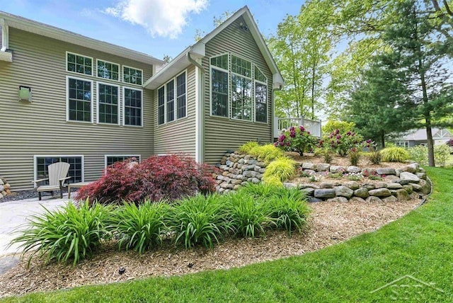 2887 E Iron Woods Pass, Midland, MI 48642 - view of side of property with a patio and a lawn