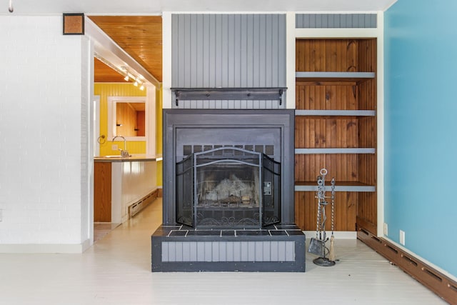 74219 Lambert Dr, South Haven, MI 49090 - detailed view of wood finished floors, baseboard heating, a large fireplace, a sink, and baseboards