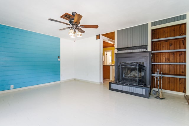 74219 Lambert Dr, South Haven, MI 49090 - unfurnished living room featuring a ceiling fan, baseboards, a large fireplace, and wood walls