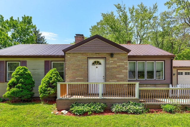 74219 Lambert Dr, South Haven, MI 49090 - ranch-style home featuring a chimney, metal roof, a wooden deck, and a front yard