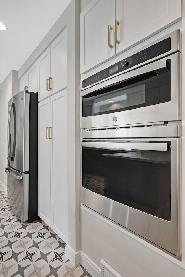 660 Sylvanwood Dr, Troy, MI 48085 - kitchen with appliances with stainless steel finishes, light flooring, white cabinets, and baseboards