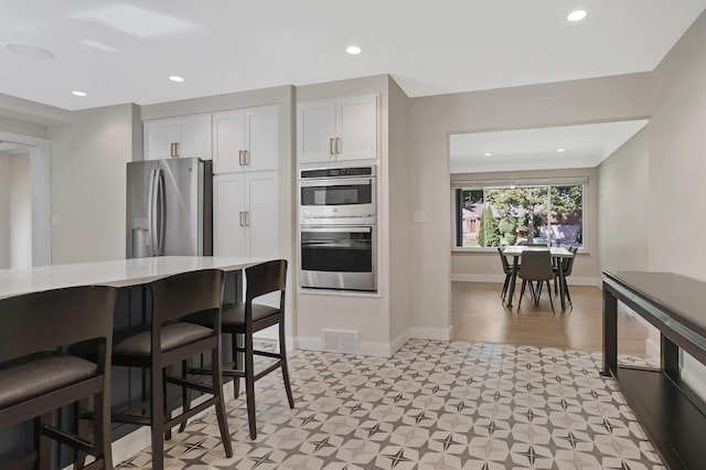 660 Sylvanwood Dr, Troy, MI 48085 - kitchen featuring stainless steel appliances, light flooring, light countertops, baseboards, and white cabinetry