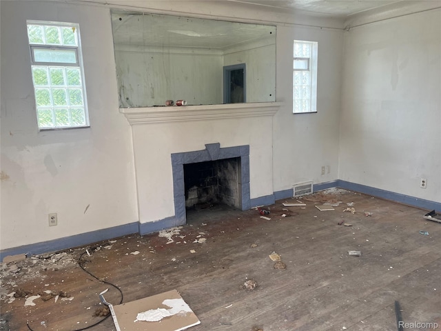 9803 Nottingham Rd, Detroit, MI 48224 - unfurnished living room featuring plenty of natural light, a fireplace with flush hearth, baseboards, and wood finished floors