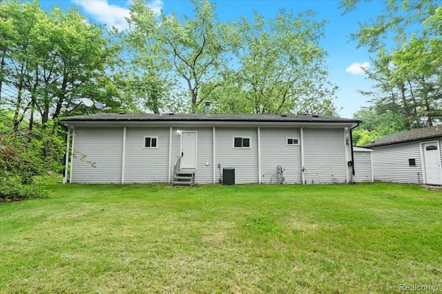1060 Apple Blossom Dr, Howell, MI 48843 - rear view of house featuring entry steps, central AC, and a lawn
