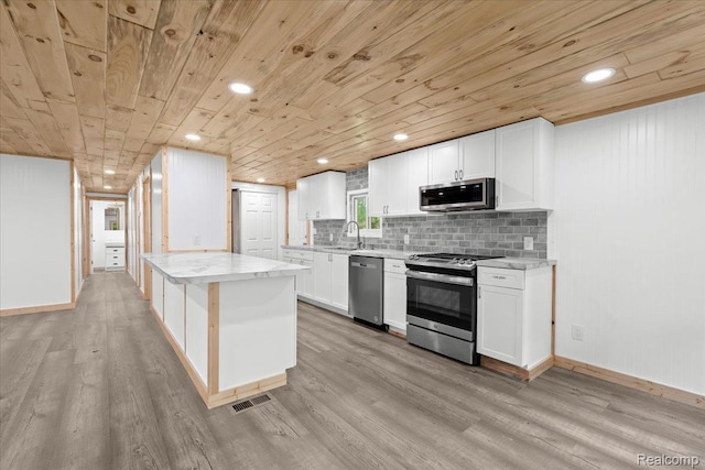 1060 Apple Blossom Dr, Howell, MI 48843 - kitchen featuring appliances with stainless steel finishes, wood ceiling, light wood-type flooring, white cabinetry, and backsplash