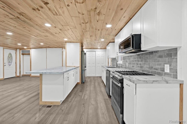 1060 Apple Blossom Dr, Howell, MI 48843 - kitchen featuring stainless steel appliances, a sink, light wood finished floors, a peninsula, and wooden ceiling