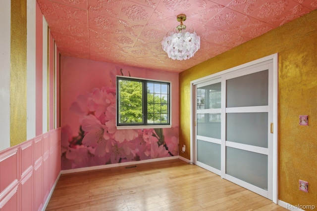 8286 Westminster Ave, Warren, MI 48089 - spare room featuring light wood-type flooring, a chandelier, and an ornate ceiling