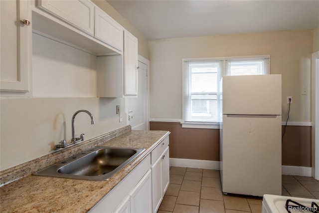46 W Arizona St, Highland Park, MI 48203 - kitchen with freestanding refrigerator, a sink, white cabinets, and baseboards