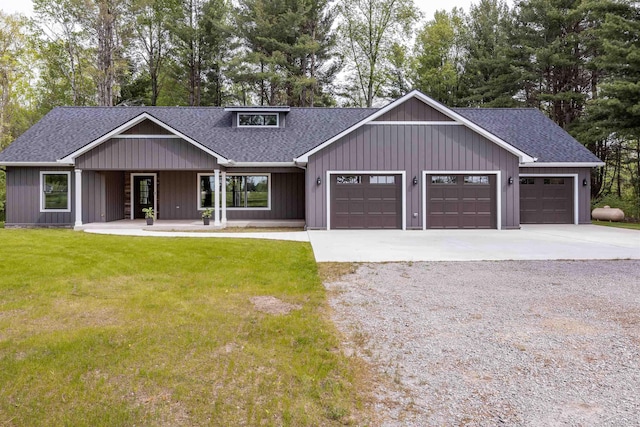2291 E Maple Rd, Clare, MI 48617 - view of front facade with roof with shingles, driveway, a garage, a front lawn, and a porch