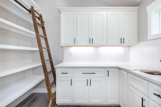 2291 E Maple Rd, Clare, MI 48617 - kitchen featuring tasteful backsplash, a sink, white cabinets, dark wood-style floors, and light stone countertops