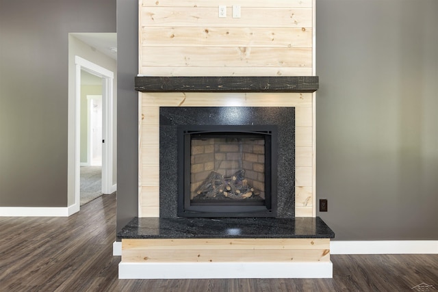 2291 E Maple Rd, Clare, MI 48617 - detailed view of baseboards, wood finished floors, and a fireplace with raised hearth