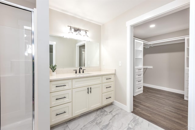 2291 E Maple Rd, Clare, MI 48617 - bathroom with a walk in closet, vanity, a shower stall, marble finish floors, and baseboards