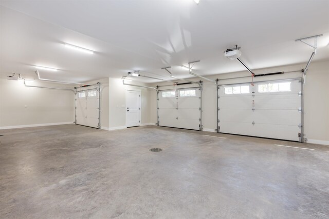 2291 E Maple Rd, Clare, MI 48617 - garage featuring a garage door opener and baseboards