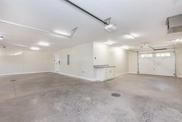 2291 E Maple Rd, Clare, MI 48617 - garage with electric panel, a garage door opener, and baseboards