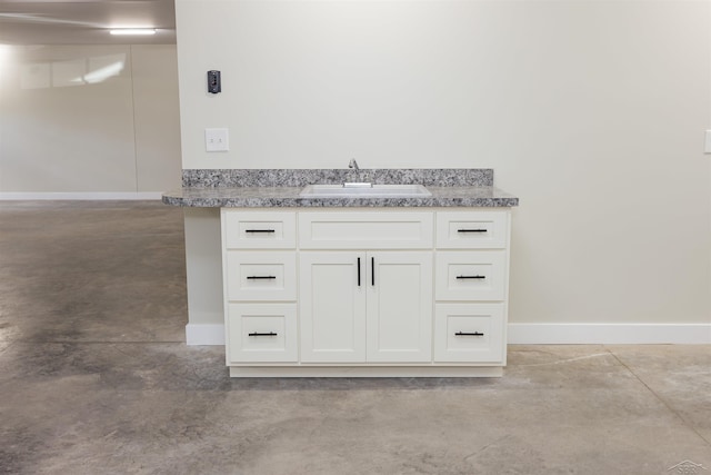 2291 E Maple Rd, Clare, MI 48617 - detailed view of a sink, concrete flooring, and baseboards