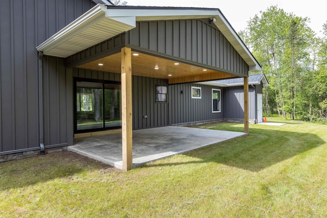 2291 E Maple Rd, Clare, MI 48617 - back of property featuring board and batten siding, a patio, and a yard