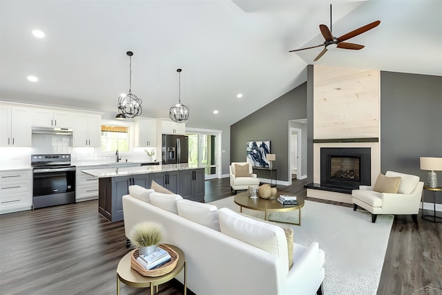 2291 E Maple Rd, Clare, MI 48617 - living room with ceiling fan, dark wood-style floors, recessed lighting, a fireplace with raised hearth, and high vaulted ceiling