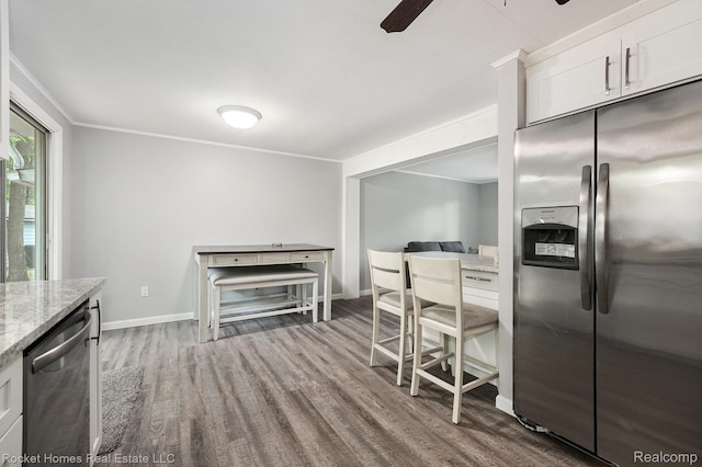 9689 Pine Ln, Evart, MI 49631 - kitchen with appliances with stainless steel finishes, dark wood finished floors, light stone counters, ceiling fan, and ornamental molding