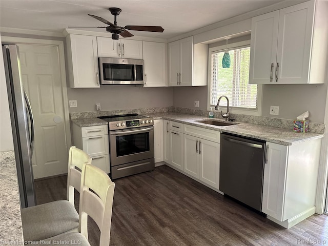 9689 Pine Ln, Evart, MI 49631 - kitchen featuring stainless steel appliances, dark wood-type flooring, white cabinetry, ceiling fan, and light stone countertops