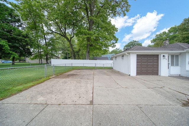 801 Briarcliff Rd, Jackson, MI 49203 - view of property exterior featuring a garage, concrete driveway, and a chimney