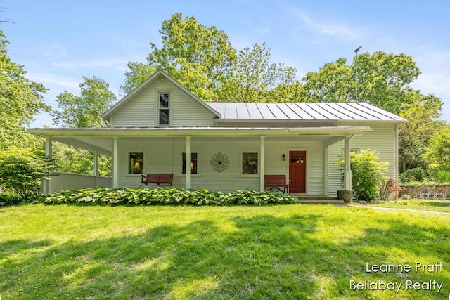 13814 28th St, Lowell, MI 49331 - view of front of home featuring a standing seam roof, a front yard, and covered porch