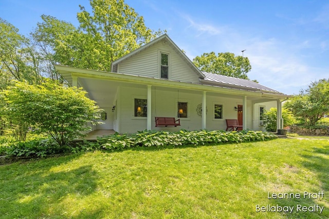 13814 28th St, Lowell, MI 49331 - view of front of property featuring a front yard, a porch, a standing seam roof, and metal roof