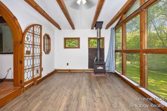 13814 28th St, Lowell, MI 49331 - unfurnished living room featuring a wood stove, wood finished floors, baseboards, and beam ceiling