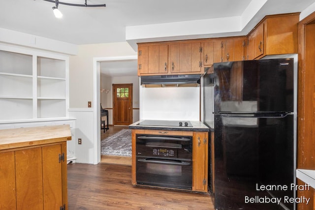 13814 28th St, Lowell, MI 49331 - kitchen featuring black appliances, under cabinet range hood, brown cabinets, wood counters, and wainscoting