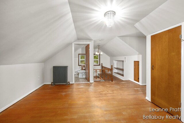 13814 28th St, Lowell, MI 49331 - additional living space featuring radiator, a chandelier, wood finished floors, lofted ceiling, and baseboards