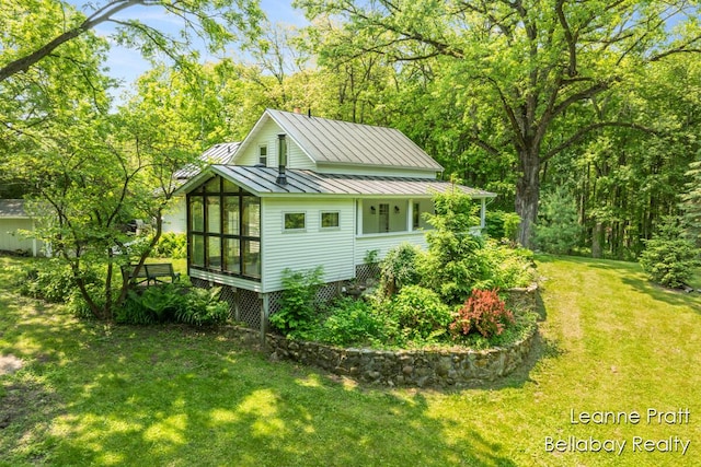 13814 28th St, Lowell, MI 49331 - view of property exterior with a standing seam roof, a sunroom, metal roof, and a lawn