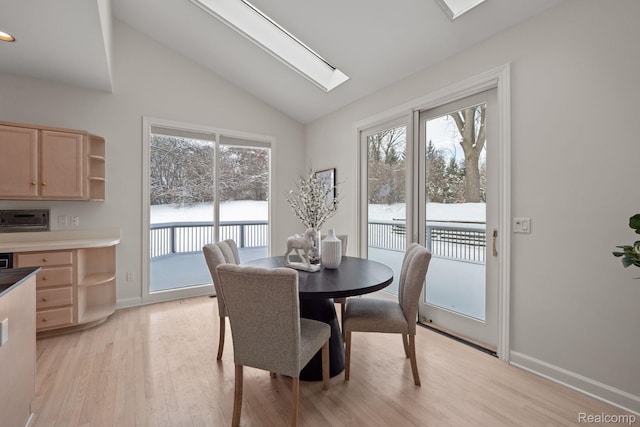 2729 Glenbrooke Ct, Bloomfield Hills, MI 48302 - dining room featuring vaulted ceiling, light wood-style flooring, a skylight, healthy amount of natural light, and baseboards