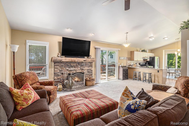 2458 Oseola Ave, Howell, MI 48843 - carpeted living room featuring healthy amount of natural light, ceiling fan, a stone fireplace, and vaulted ceiling