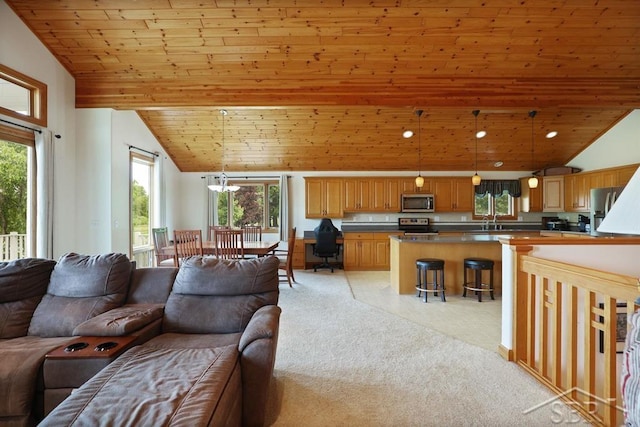 681 Quillett Dr, Beaverton, MI 48612 - living room with vaulted ceiling, wood ceiling, plenty of natural light, light colored carpet, and a chandelier
