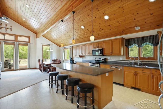 681 Quillett Dr, Beaverton, MI 48612 - kitchen featuring appliances with stainless steel finishes, high vaulted ceiling, a sink, a breakfast bar, and dark countertops
