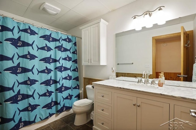 681 Quillett Dr, Beaverton, MI 48612 - bathroom featuring toilet, vanity, wainscoting, a shower with shower curtain, and a paneled ceiling