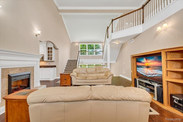 10726 Davisburg Rd, Davisburg, MI 48350 - living area featuring a tile fireplace, baseboards, high vaulted ceiling, stairway, and ornamental molding
