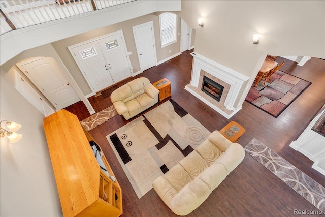 10726 Davisburg Rd, Davisburg, MI 48350 - living area with arched walkways, wood finished floors, a fireplace with raised hearth, baseboards, and a towering ceiling