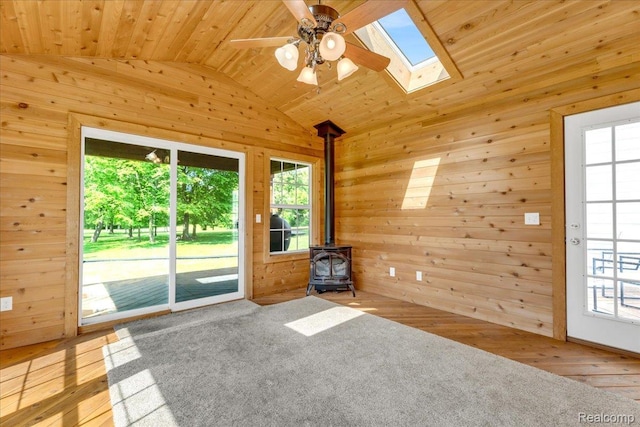 10726 Davisburg Rd, Davisburg, MI 48350 - unfurnished living room with a wood stove, a skylight, lofted ceiling, wooden walls, and wooden ceiling