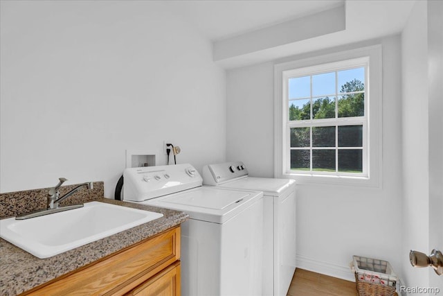 10726 Davisburg Rd, Davisburg, MI 48350 - washroom featuring separate washer and dryer, cabinet space, baseboards, and light wood-style flooring