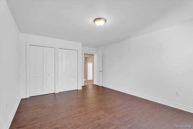10726 Davisburg Rd, Davisburg, MI 48350 - unfurnished bedroom with two closets, baseboards, and wood finished floors
