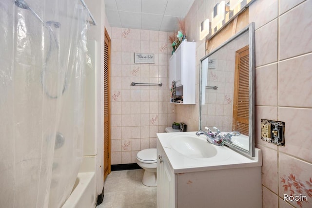 1032 White Ave NW, Grand Rapids, MI 49504 - bathroom featuring tile walls, toilet, tile patterned floors, vanity, and shower / bath combo with shower curtain