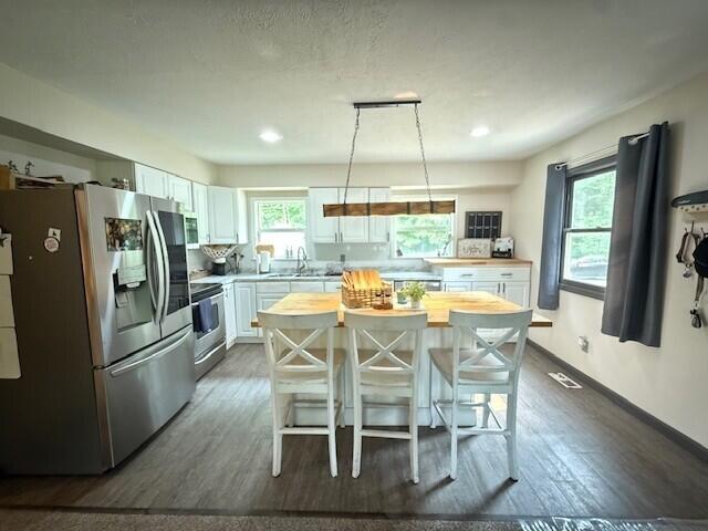 17912 130th Ave, Nunica, MI 49448 - kitchen featuring appliances with stainless steel finishes, healthy amount of natural light, wooden counters, white cabinetry, and recessed lighting