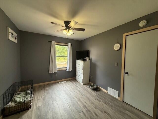 17912 130th Ave, Nunica, MI 49448 - unfurnished bedroom with wood finished floors, baseboards, and a ceiling fan